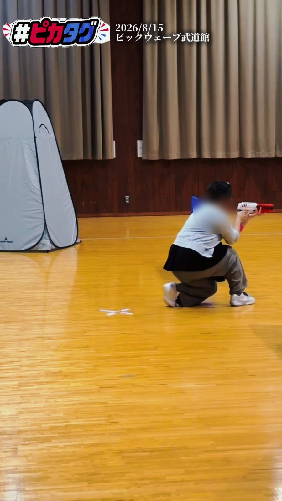 武道場に障害物を並べたフィールドで、陰にひざをついて構える