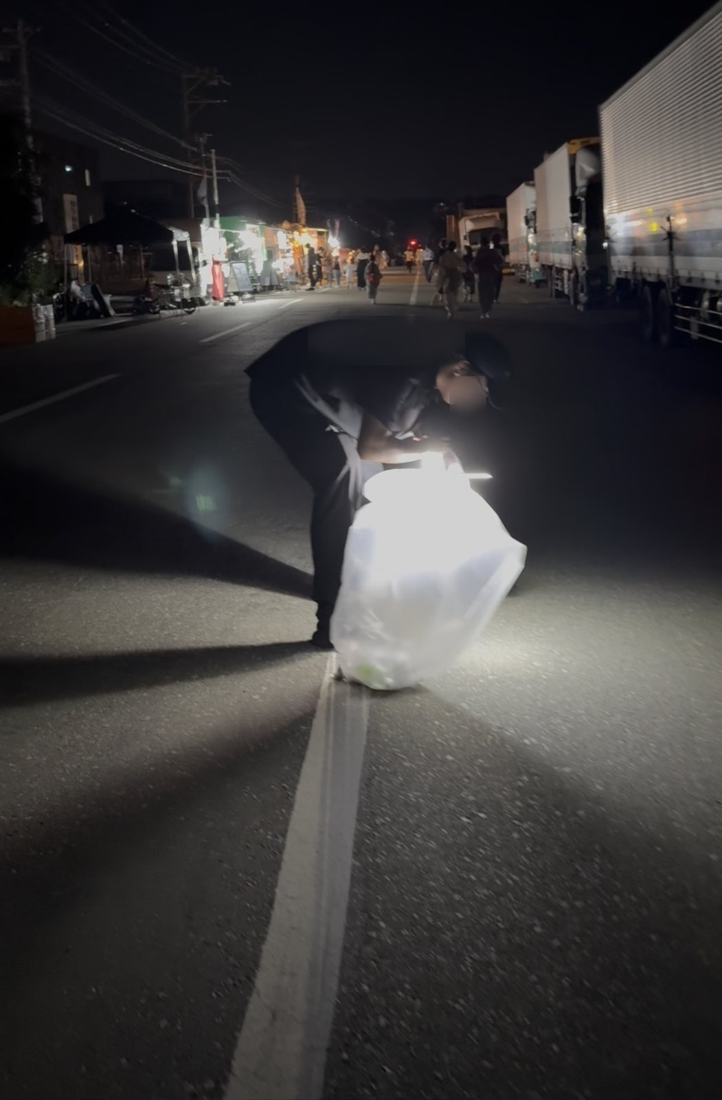 花火のあと、道路のゴミを拾う