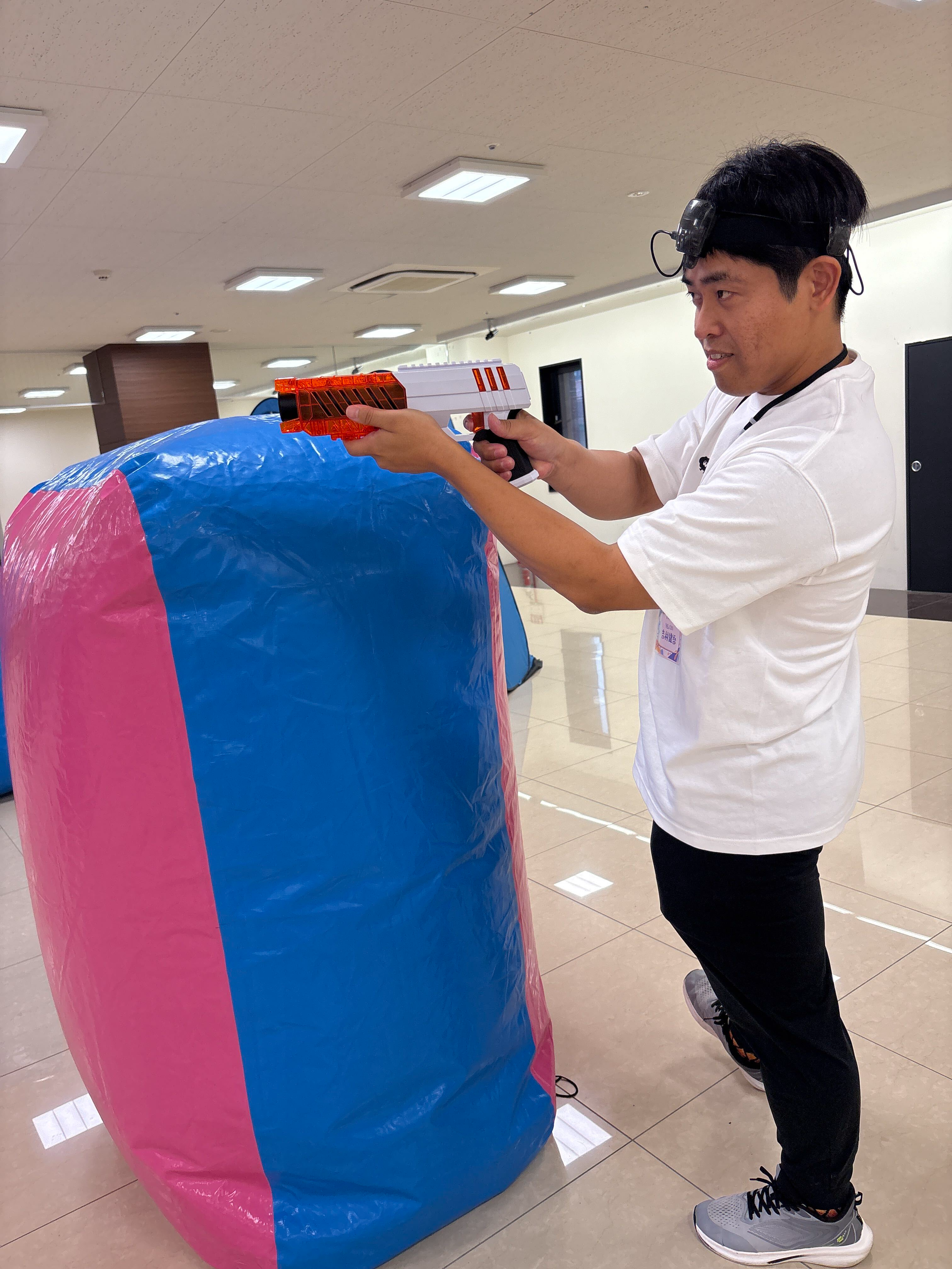 シューターを構えてピカタグを体験する、株式会社スタディブレインの吉村塾長。