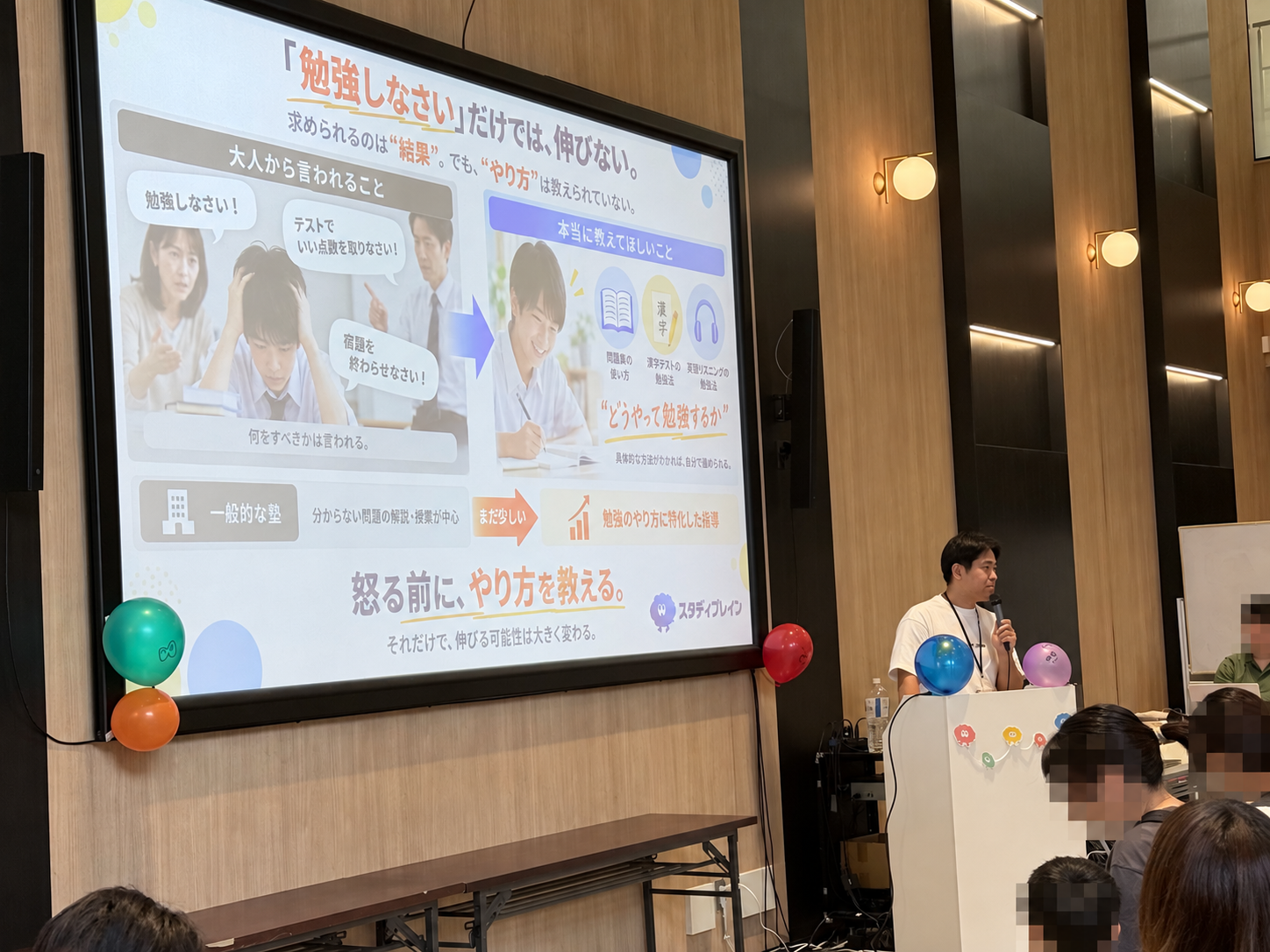 吉村塾長の講演。スライドには「怒る前に、やり方を教える。」の言葉が掲げられていました。