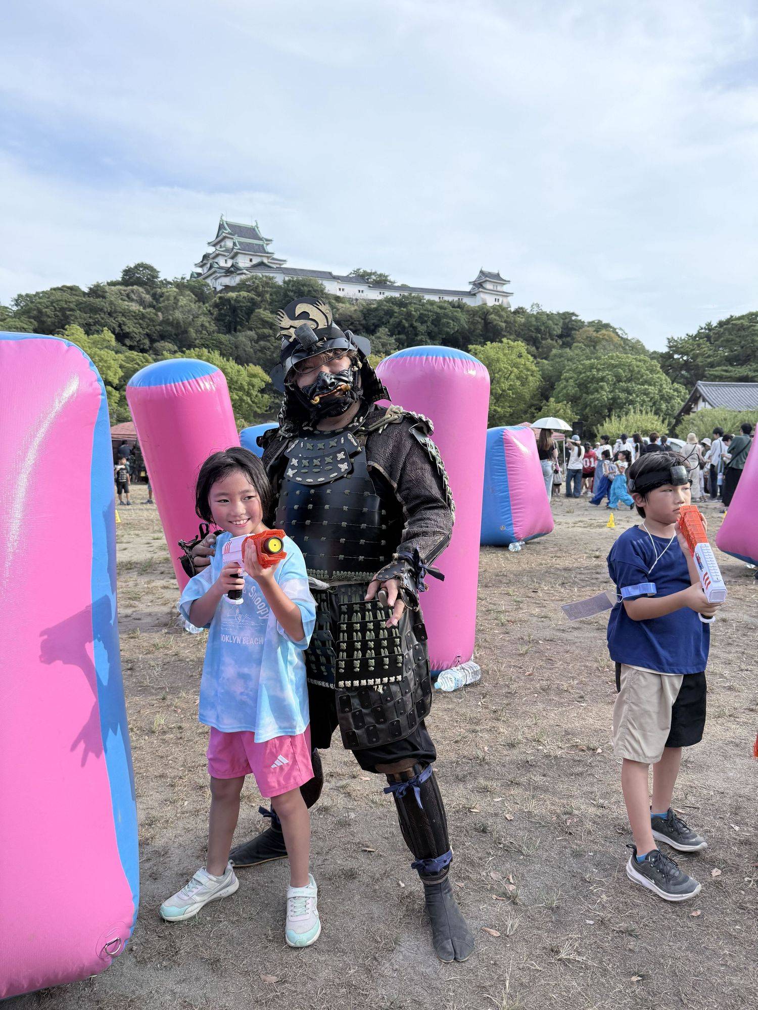 甲冑姿の方と、ブラスターを持つプレイヤー。背景に和歌山城