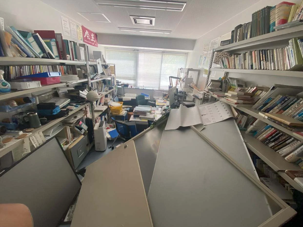 本棚や書類が倒れた室内